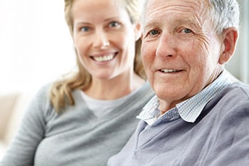Lächelnder älterer Mann mit seiner Tochter, die zufrieden mit der Kontrolle der COPD-Symptome sind
