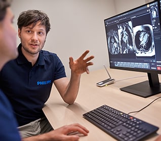 Zwei klinische Mitarbeiter besprechen MR-Aufnahmen auf dem Monitor