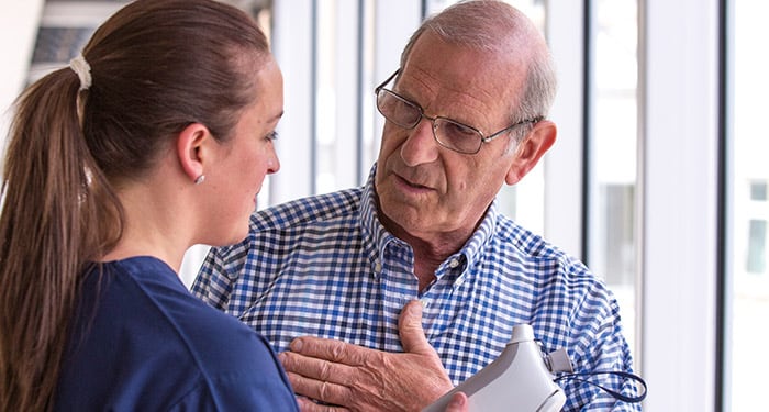 Mann, der mit einem medizinischen Betreuer die Behandlung zur Linderung der COPD-Symptome im Stadium III bespricht