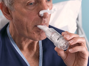Mann mit Nasenklammer bei der Benutzung des Muskeltrainers Threshold IMT