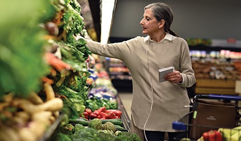 Frauen mit tragbarem Simply Go Mini Sauerstoffkonzentrator wählen Gemüse aus