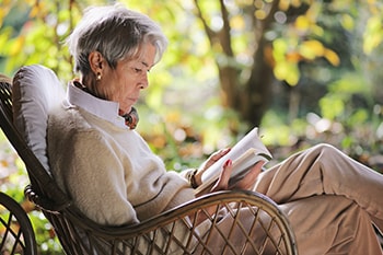 Frauen sitzen lesend im Garten