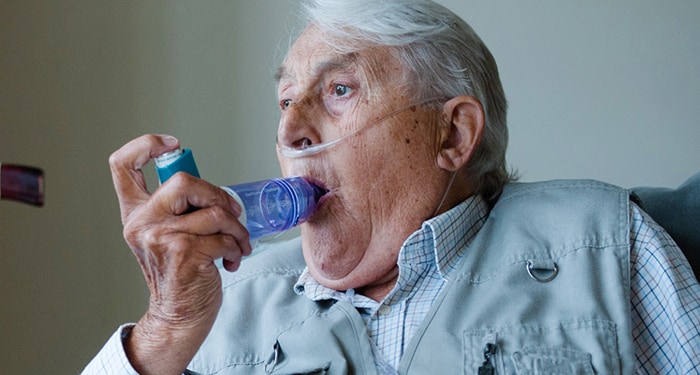 Gentleman using his OptiChamber Diamond spacer attached to his medication inhaler