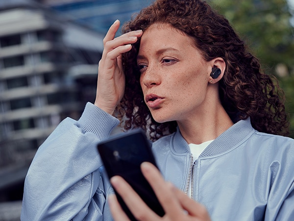 Frau genießt die Crystal Call-Funktion der Philips Kopfhörer