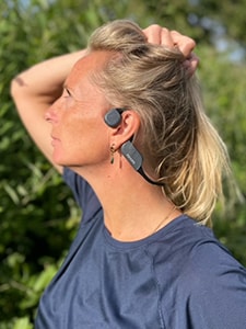 Frau mit Philips Kopfhörern mit Bluetooth und Knochenschall-Übertragung