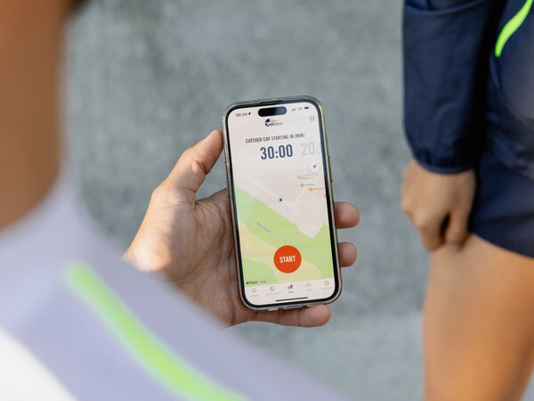 Ein Teilnehmer am Lauf checkt sein Telefon und wartet auf den Startschuss für den Lauf.