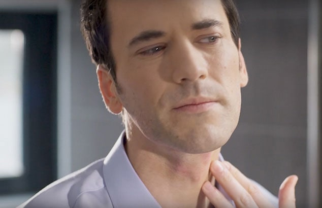 Ein Mann, der sich mit den Fingern an den Hals greift und seine Haut auf Rasierpickel untersucht.