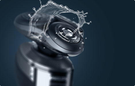 Foto eines Philips Rasierapparats, der mit Wasser bespritzt wird.