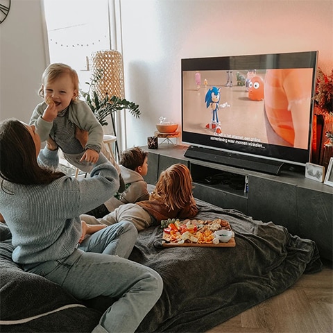 Familie, die Ambilight-Fernsehen sieht