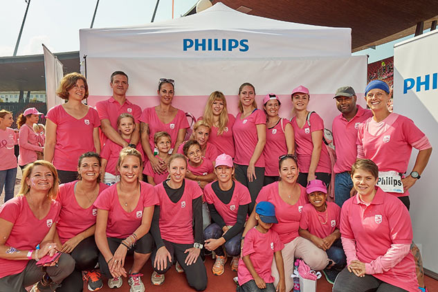 Philips Mitarbeitende mit Familie und Freunden vor der Fotowall beim Philips Stand.