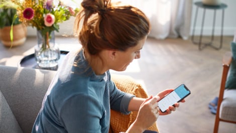 Patientin schaut auf Mobiltelefon App (öffnet sich in einem neuen Fenster)